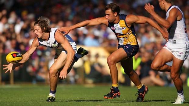 Nat Fyfe of the Dockers gathers a low ball before Dom Sheed of the Eagles has a chance to get to it.