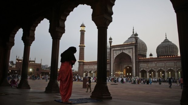 An Indian Muslim woman performs a prayer after breaking her fast on the first day of the holy fasting month of Ramadan at Jama Masjid in New Delhi, India.