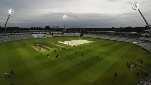 The England cricket team train under floodlights during a nets session.