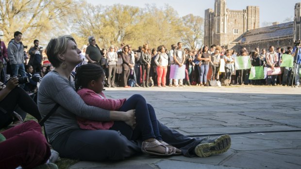 Kendall Baker, 6, sits with her mother and Duke University staff member Dana Creighton during a university-wide forum outside the Duke Chapel on campus.
