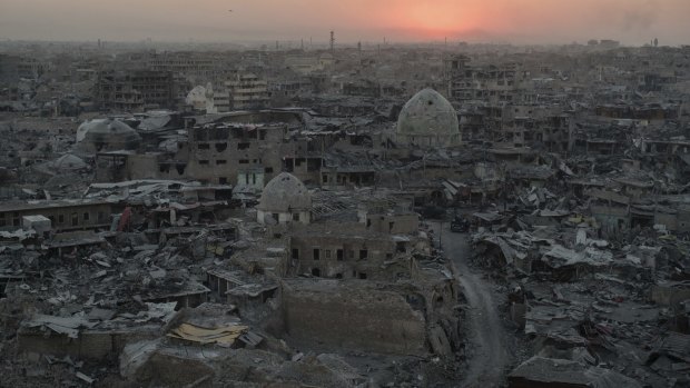 The sun sets behind destroyed buildings in the west side of Mosul in 2017.
