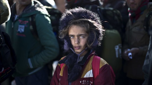 Yazidi refugee Salma Bakir, 9, from Iraq, waits with her family to be permitted by Macedonian police to board a train heading to the Serbian border last year.