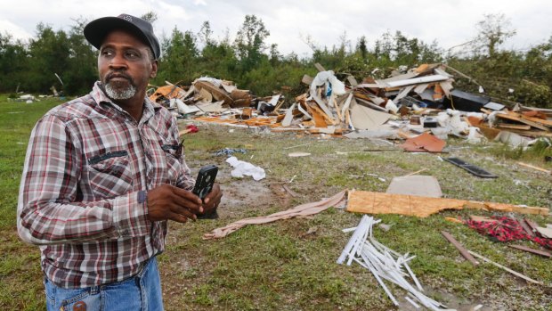 Wayne Doss surveys the damage to his cousin Danny Doss' mobile home destroyed by a tornado in Alabama on Thursday, as the remnants of Harvey came through the state.