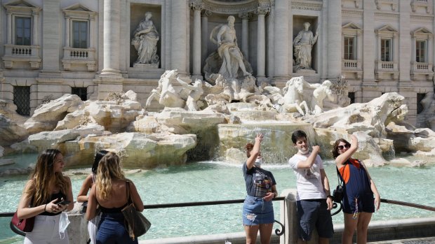 Tourists throw their coins into Rome's Trevi Fountain in June as restrictions were lifted across Italy.