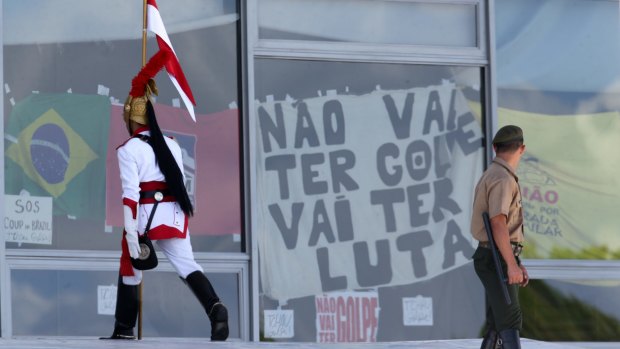 A banner that says in Portuguese: "There'll be no coup. There will be a fight," hangs inside the window of Planalto presidential palace in Brasilia, on Monday.