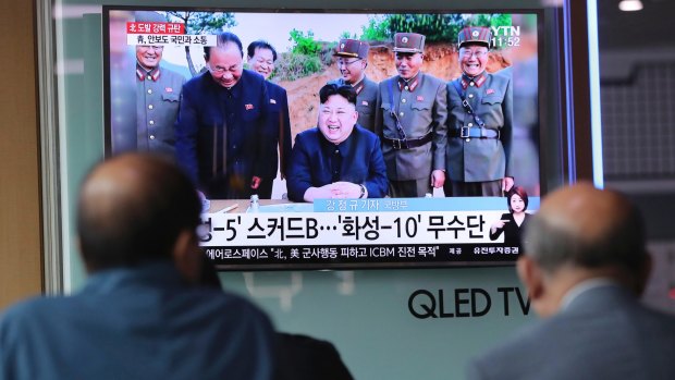 People in South Korea watch a TV news program showing an image of North Korean leader Kim Jong-un on Monday.