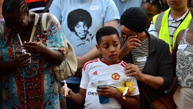 Emotions run high as people attend a candle lit vigil outside Notting Hill Methodist Church near the Grenfell Tower block.