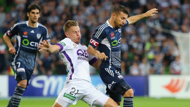 Victory's Kosta Barbarouses competes with Glory's  Scott Jamieson as teammate Gui Finkler looks on.