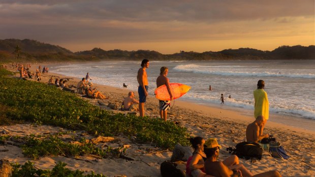 Fifteen minutes of sunshine everyday: People enjoy a sunset on Playa Guiones beach, Nosara, Nicoya Peninsula, Costa Rica.
