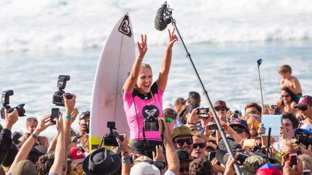 Surrounded by fans and their cameras, Stephanie Gilmore celebrates another surfing success. 