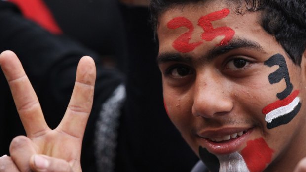 A young man with the date 25 painted on his face, gives the victory sign in Tahir Square ahead of the first anniversary of the revolution in 2012 in Cairo. Egypt has become more repressive since then.