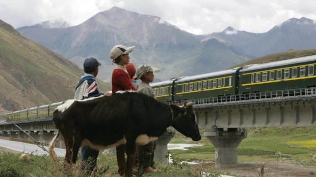 A Train from Lhasa Railway Station travels on the Tibetan grasslands near Lhasa, Tibet.