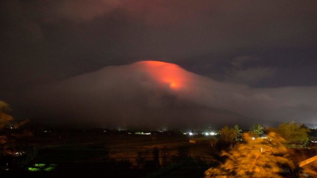 An orange glow is seen at the cloud-shrouded crater of Mayon on Sunday.