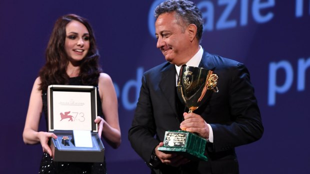 A Jaeger-LeCoultre Unique Reverso watch is held to go along with as Paolo Del Brocco (R) accepts the Coppa Volpi for Best Actress for Emma Stone for La La Land during the Venice's closing ceremony.