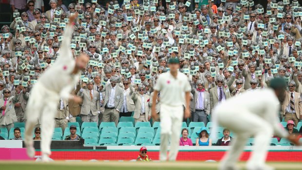 Nathan Lyon bowls as the Richie Benaud impersonators hold up their microphones during day two of the third Test against the West Indies at the SCG last year.