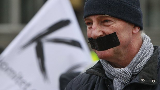 A demonstrator seals his mouth during a protest over media freedom at the Polish TVP News headquarters in Warsaw.
