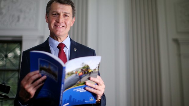 Mayor Graham Quirk looks through the Brisbane City Council annual budget book at Brisbane City Hall.