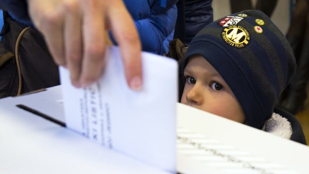 A child looks at a ballot being cast at a polling station in Zagreb on Sunday.