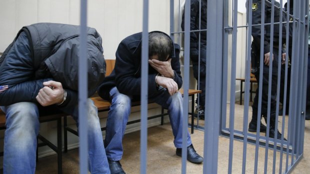 Shagid Gubashev and Ramzan Bakhayev hide their faces at court on Sunday.  