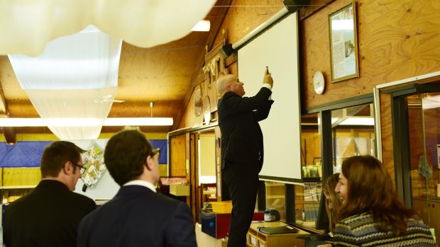 Adrian Piccoli photographs a story on a library wall about David Gonski's visit to Villawood North Public School. 
