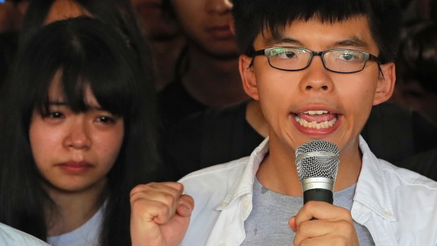 Joshua Wong, right, chants slogans as a supporter, left, reacts outside the high court before a ruling on a prosecution request for stiffer sentences in Hong Kong on Thursday.