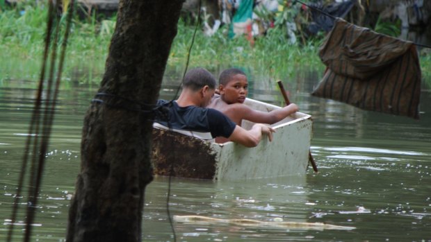 Children use an old wooden box as a boat at an area flooded by the rains of Hurricane Matthew in the La Puya slum in Santo Domingo Domingo, Dominican Republic.