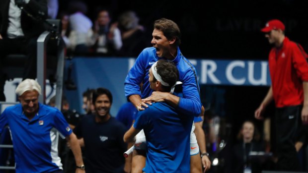 Roger Federer celebrates with teammate Rafael Nadal after the win.