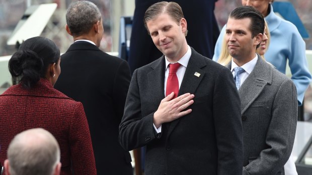 Speaking on matters of state: Eric Trump, centre, with Donald Trump jnr, acknowledge Barrack and Michelle Obama at their father's presidential inauguration.