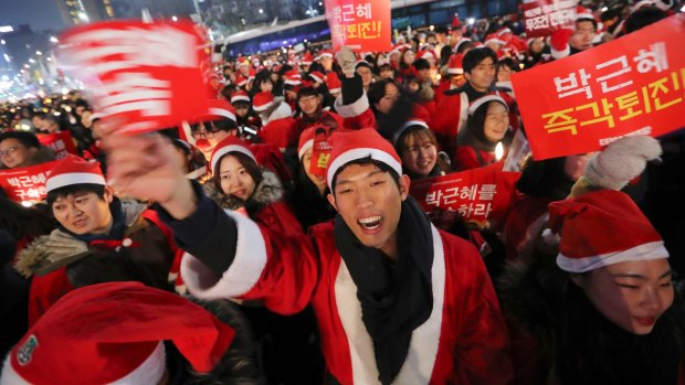 People wearing Santa Claus outfits calls for the resignation of South Korean President Park Geun-hye.