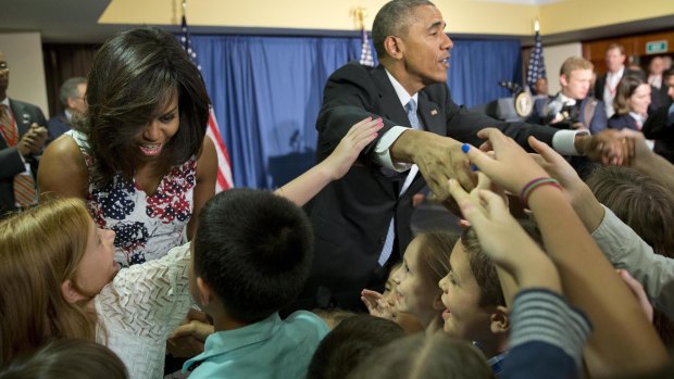 Historic visit: Barack Obama and wife Michelle greet families of embassy personnel in Havana. 