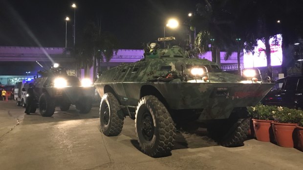 Military vehicles are positioned outside the Resorts World Manila.
