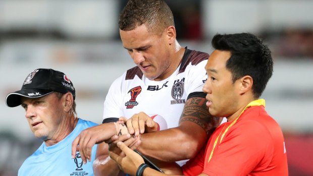 Painful blow: Kane Evans comes off the field with a wrist injury at Townsville Stadium.
