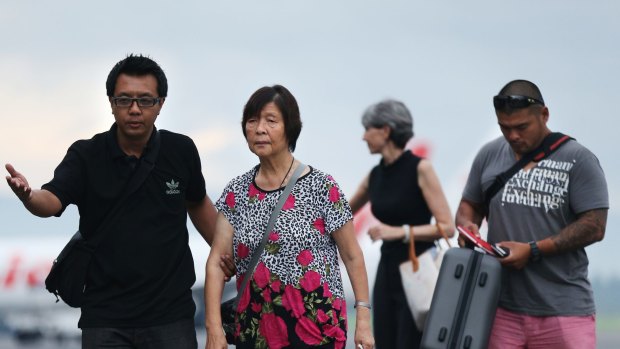 Australian Consulate staff assist Helen Chan, the mother of Bali Nine member Andrew Chan, followed by his brother Michael Chan as they arrived at Yogyarkarta airport on Thursday.