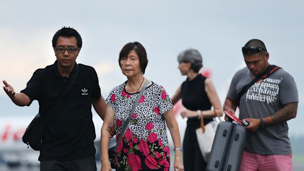 Australian Consulate staff assist Helen Chan, the mother of Bali Nine member Andrew Chan, followed by his brother Michael Chan as they arrived at Yogyarkarta airport on Thursday.