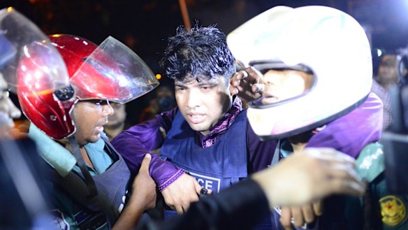An injured Bangladeshi policeman being assisted after the attack.