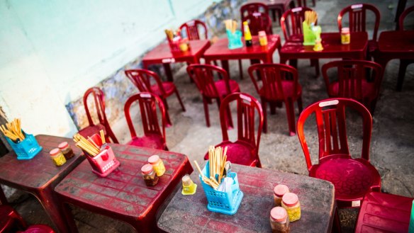 Street-side eating takes place at tiny plastic chairs pulled up to low tables.
