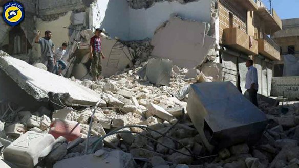 In a picture provided by the Syrian Civil Defence group, Syrians inspect damaged buildings after air strikes hit the Bustan al-Qasr neighbourhood of Aleppo.