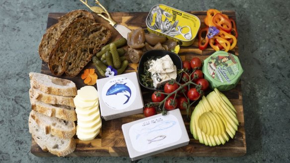 An example of a tinned fish platter with pickles and accompaniments.