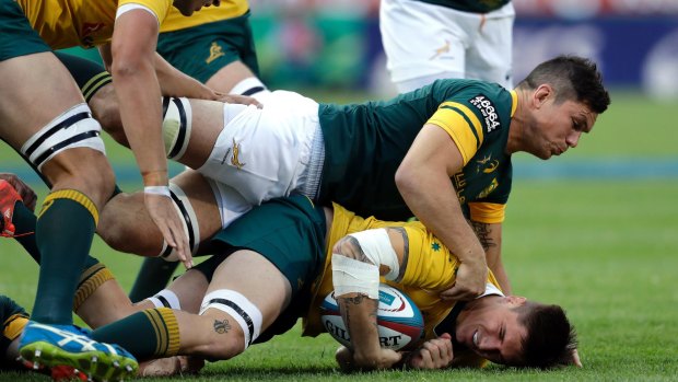 Australia's Sean McMahon is tackled by South Africa's Francois Louw.