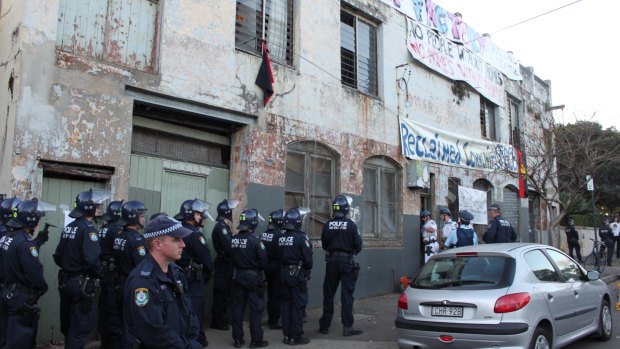 Police in riot gear as the first door at the Hat Factory is destroyed.