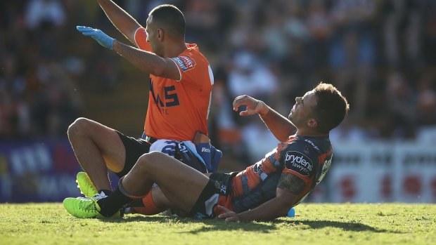 Blow: Tigers halfback Luke Brooks goes down with a hamstring injury.