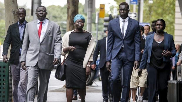 Former North Melbourne player Majak Daw (in blue suit) outside the County Court with his family on Monday. 