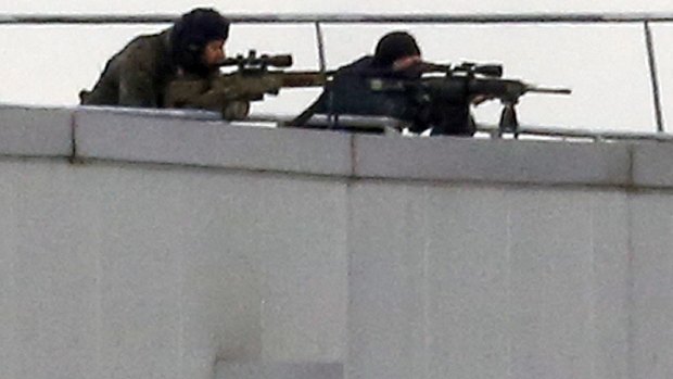 Before the assault: French special forces take position with sniper rifles on the rooftop of a complex at an industrial building in Dammartin-en-Goele, northeast of Paris.
