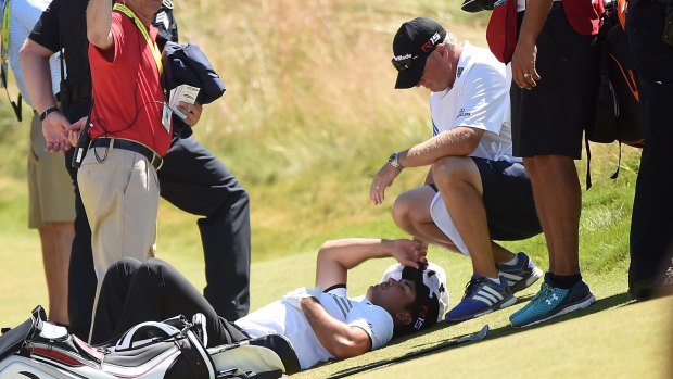 Challenges: Jason Day is tended to by his caddie as he lays on the ninth green after a dizzy spell at the 2015 US Open.