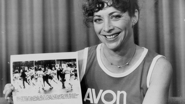Switzer, pictured in 1983 holding a series of photographs depicting an official attempting to force her from the course in 1967.