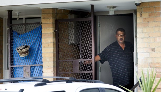 A man looks on to the street full of waiting media from his Heidelberg West home.