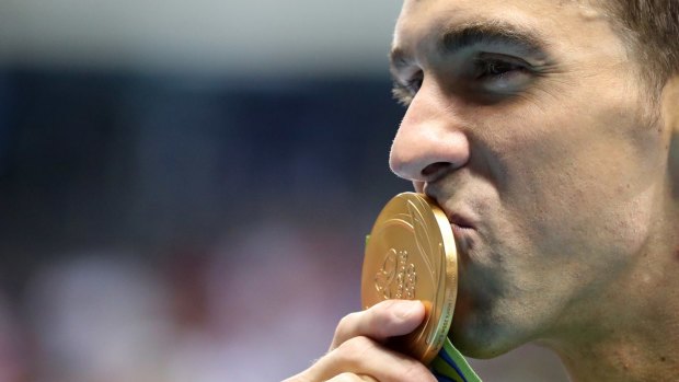United States' Michael Phelps celebrates with his gold medal after the men's 200m butterfly.