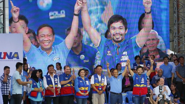 Philippine Vice President Jejomar Binay, second from right, raises the hands of senatorial candidate, boxer and Congressman Manny Pacquiao, right, who is widely popular in his home country.