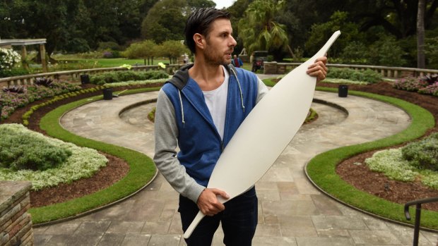 Artist Jonathan Jones holds one of the 15,000 ceramic Aboriginal shields that will outline the lost Garden Palace in the Royal Botanic Gardens.
