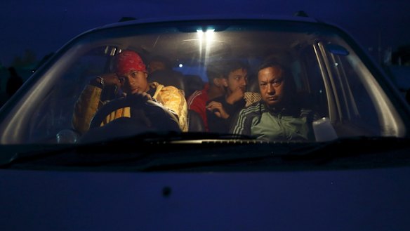 People sit inside their car on open ground to keep safe after an earthquake in Kathmandu.